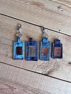 three small wallets are hanging on a wooden surface, one is blue and the other is brown