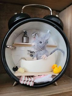 a toy mouse in a bathtub surrounded by other items