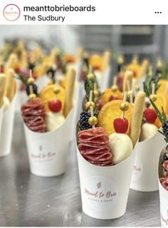 many small cups filled with different types of food on top of a metal countertop