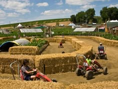 people are sitting on hay bales in the middle of an open field with farm equipment