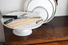 a white plate with chopsticks and a knife on it sitting on top of a wooden table