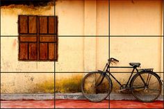 a bike parked next to a building with two windows on it's sides and a red floor