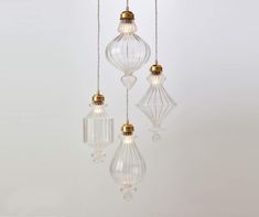 three clear glass pendant lights hanging from a ceiling