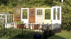 an old outhouse sits in the middle of a yard with plants growing on it