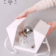 a person holding an origami box with the lid open to show it's contents