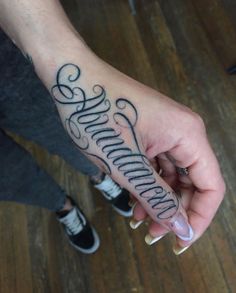 a person with a tattoo on their left hand holding onto the word'love and affection '