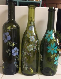 three green vases with flowers painted on them