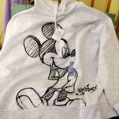 a sweatshirt with a drawing of mickey mouse on it's chest and the name disney written on it