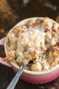 a pink bowl filled with oatmeal on top of a table