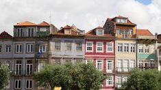 many different colored buildings with trees in the foreground