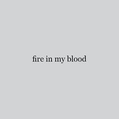 the words fire in my blood are black and white on a gray background, against a grey backdrop