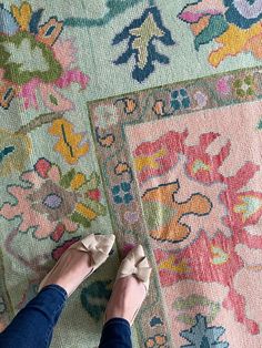 a woman standing on top of a rug with her feet propped up against the carpet