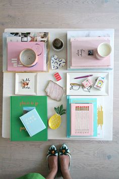 a person's feet on the floor next to various stationery and office supplies