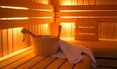 a wooden sauna with a bucket and towel on it