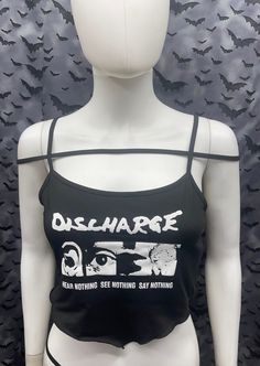 This is a black sleeveless strappy Discharge cropped tank top with a bandana style front. This has a Discharge image screen printed on the front. 91% polyester/ 9% elastane These are handmade screenprinted and slightly vary from the photo. Please feel free to email me any questions. Thanks for looking. The seller is not responsible for any lost or stolen packages. Edgy Stretch Tank Top With Graphic Print, Stretch Punk Crop Top For Streetwear, Fitted Alternative Style Tank Top With Graphic Print, Fitted Black Crop Top Band Merch, Edgy Stretch Crop Top With Tank Straps, Edgy Cropped Top For Streetwear, Cropped Grunge Tops For Streetwear, Grunge Cropped Top For Streetwear, Fitted Black Emo Tank Top