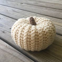 a knitted pumpkin sitting on top of a wooden table