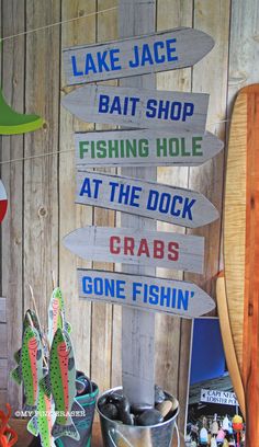 there are many signs on the wooden pole that say fishing and crabs, one fishin '