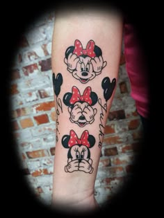 a woman's arm with mickey and minnie mouse tattoos on it