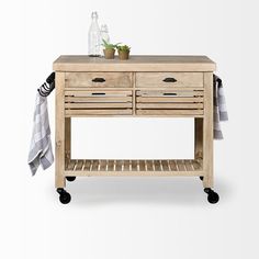 a wooden table with two drawers and a towel on it's rack next to a potted plant