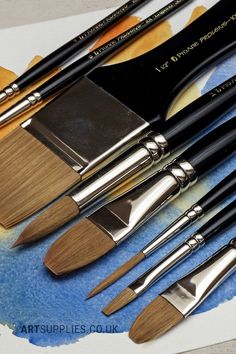 a bunch of paint brushes sitting on top of a table