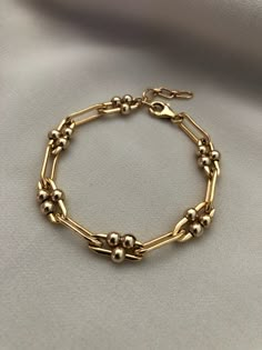 "A thick gold, long link bracelet with moving ball details. Made of high quality 14kt gold filled, this bracelet is a timeless staple for your wardrobe. Chain width is approximately 5.5mm. Gold filled balls are approximately 4mm. This listing is for the single gold chain bracelet. Measures: S/M 6\" with 1\" extender M/L 7\" with 1\" extender Length pictured at S/M ------------------------------------------------------------------------------------------------------------------- >> Check ou Luxury Gold Link Bracelet Fine Jewelry, Elegant Luxury Oval Chain Bracelet, Gold Bracelets With Satellite Chain For Formal Occasions, Formal Gold Bracelets With Satellite Chain, 14kt Gold Jewelry, Dope Jewelry Accessories, Gold Chain Bracelet, Gold Link Bracelet, Small Bracelets