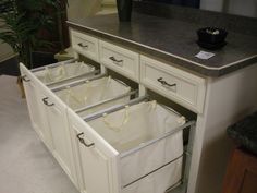 an open kitchen cabinet with two bags in the bottom drawer and one bag on the lower drawer