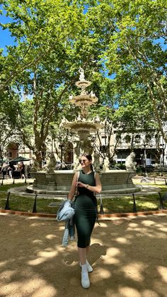 a woman standing in front of a fountain