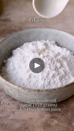 a bowl filled with white powder next to a measuring spoon