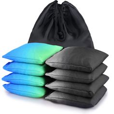 five pillows stacked on top of each other in front of a black drawsack bag