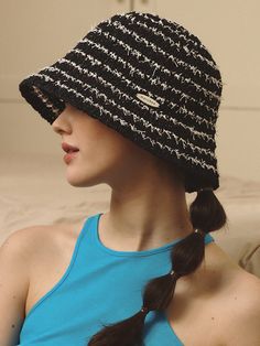 a woman wearing a black and white hat with braids on her hair is sitting down