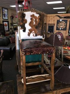 a cowhide chair in a store with other furniture and decor on the wall behind it