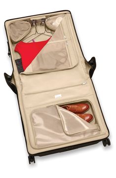 an open suitcase with clothes and shoes in it's compartment, on a white background