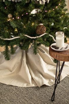 a small christmas tree is decorated with ornaments and lights, along with a glass of milk