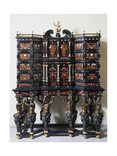 an ornately decorated wooden cabinet with two legs