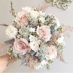 a bridal bouquet is being held by someone's hand in front of a mirror