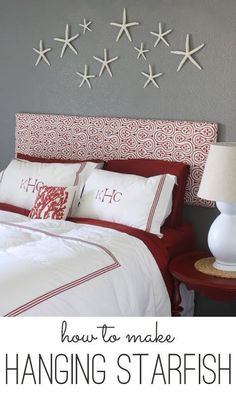 a bed with white and red pillows on top of it next to a night stand