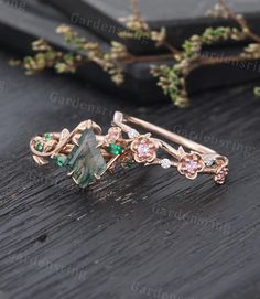 a close up of a ring on a wooden surface with flowers and leaves in the background