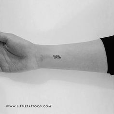 a person's arm with a small tattoo on it