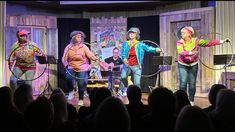 a group of people standing on top of a stage with hoop rings in front of them