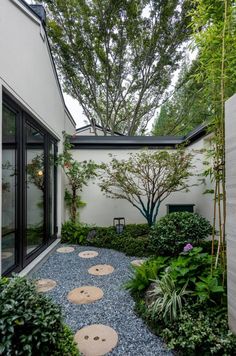 an outdoor garden with stepping stones and trees