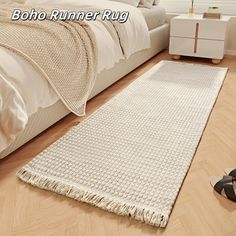 a white rug sitting on top of a wooden floor next to a pair of black shoes