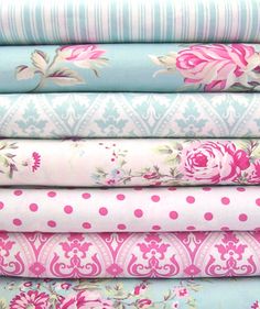 a stack of pink and blue fabric with roses on them, all in different colors