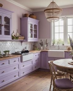 a kitchen with purple cabinets and white counter tops, wooden flooring and a chandelier hanging from the ceiling