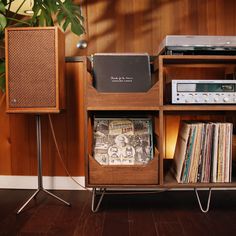 an old record player is sitting on a shelf next to a stereo system and bookshelf