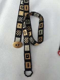 a black and gold beaded lanyard on a white shirt