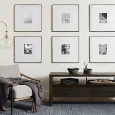 a living room with pictures on the wall and a coffee table in front of it