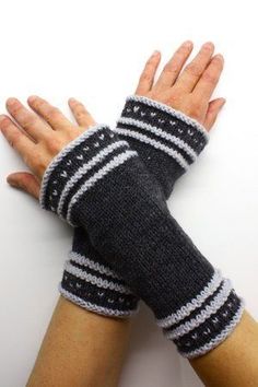 two hands wearing knitted arm warmers on top of each other with one hand in the air