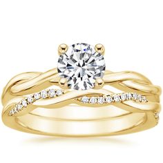 a yellow gold wedding ring set with a round diamond in the center and two rows of diamonds on each band