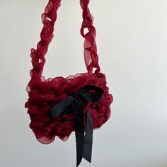 a red purse with a black bow hanging from it