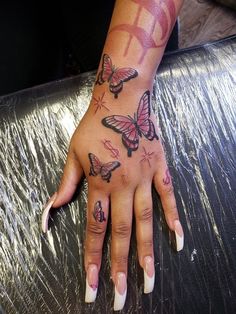 a woman's hand with butterfly tattoos on it